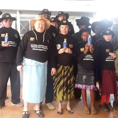 Albinism awareness participants holding protective products